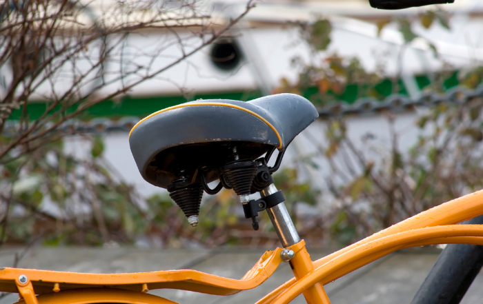 Black bike seat on an orange frame